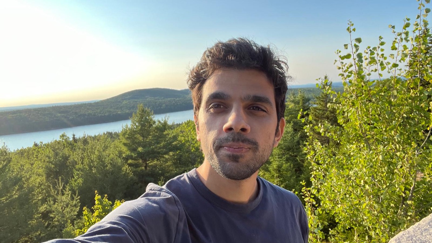 Arun, founder of Fyllyo, outdoors above a lake and forest